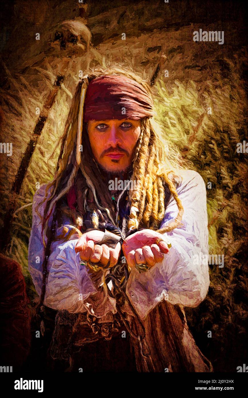 Captain Jack Sparrow impersonator holding out his hands with iron shackles on his wrist.  The character is not Johnny Depp. Stock Photo