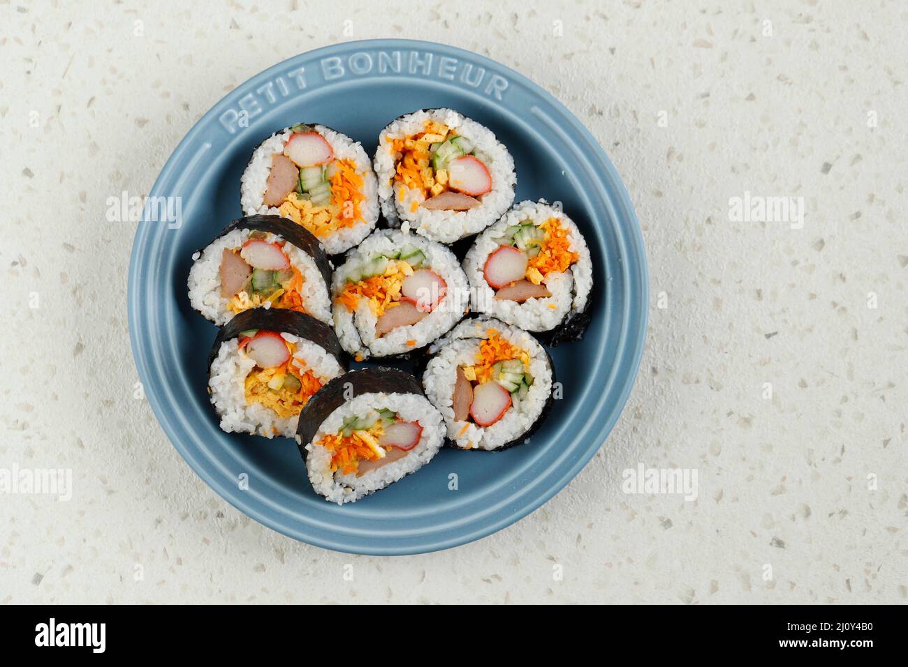 Gimbap or Kimbap, Korean Roll Rice with Nori Laver, Egg, Crab Stick, carrot, and Cucumber. Top View on Ceramic Plate, Copy Space Stock Photo