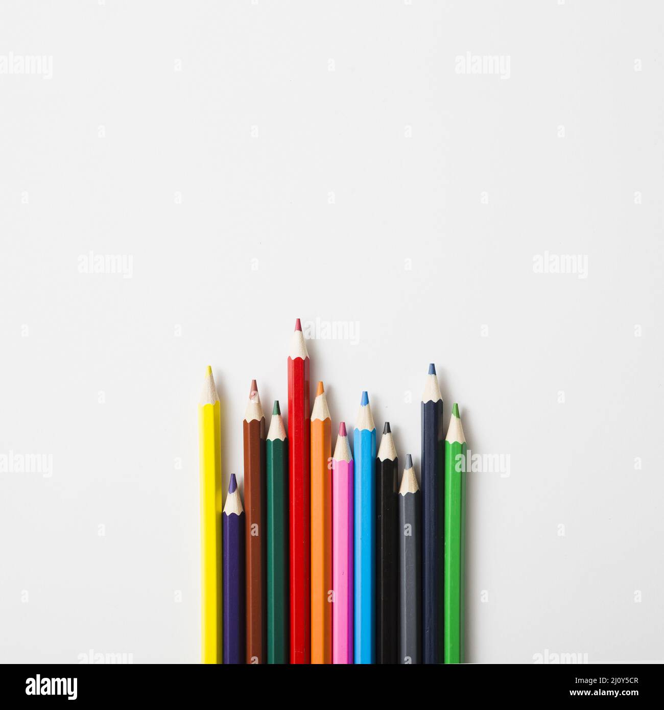 Row sharp colored pencils against white background. High quality photo Stock Photo