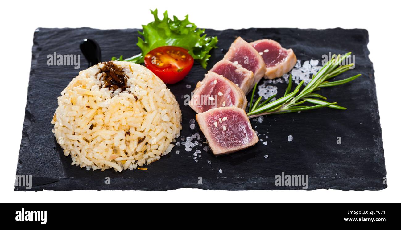 Deliciously lightly fried tuna with rice, served with greens and tomatoe Stock Photo
