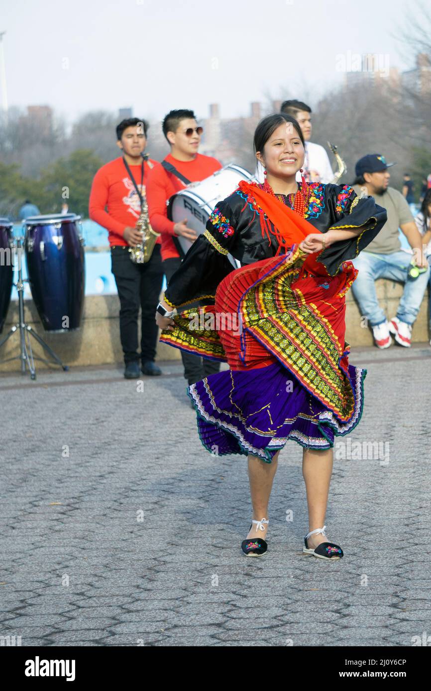 A teenage member of Jatary Muzhucuna, an Ecuadorian American music & dance troupe, performs near the a park in Queens, New York City. Stock Photo