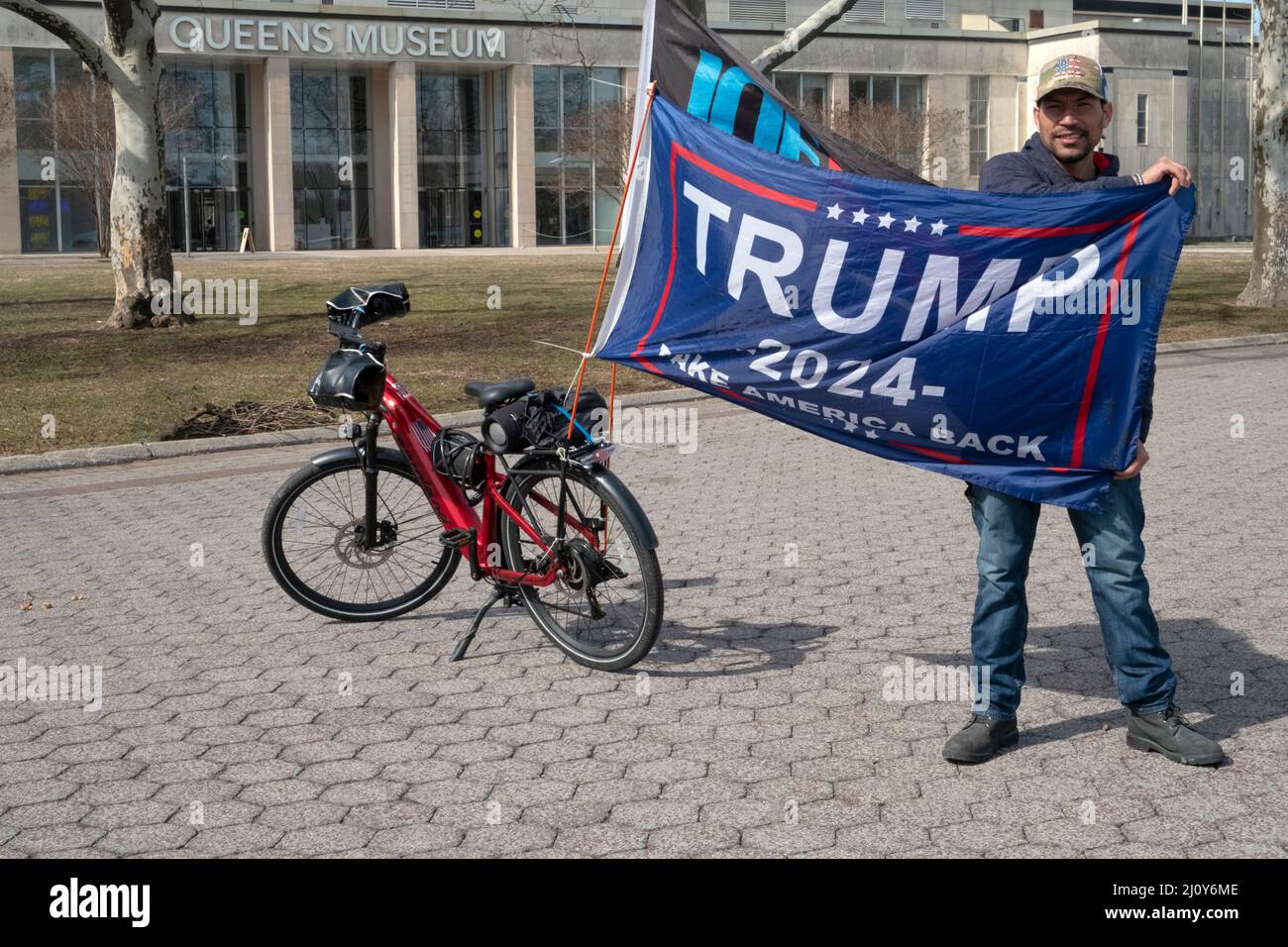 Dominican American right wing Trump supporter who rides around on his bike with pro Trump and anti Biden banners. In a park in Queens, New York City. Stock Photo