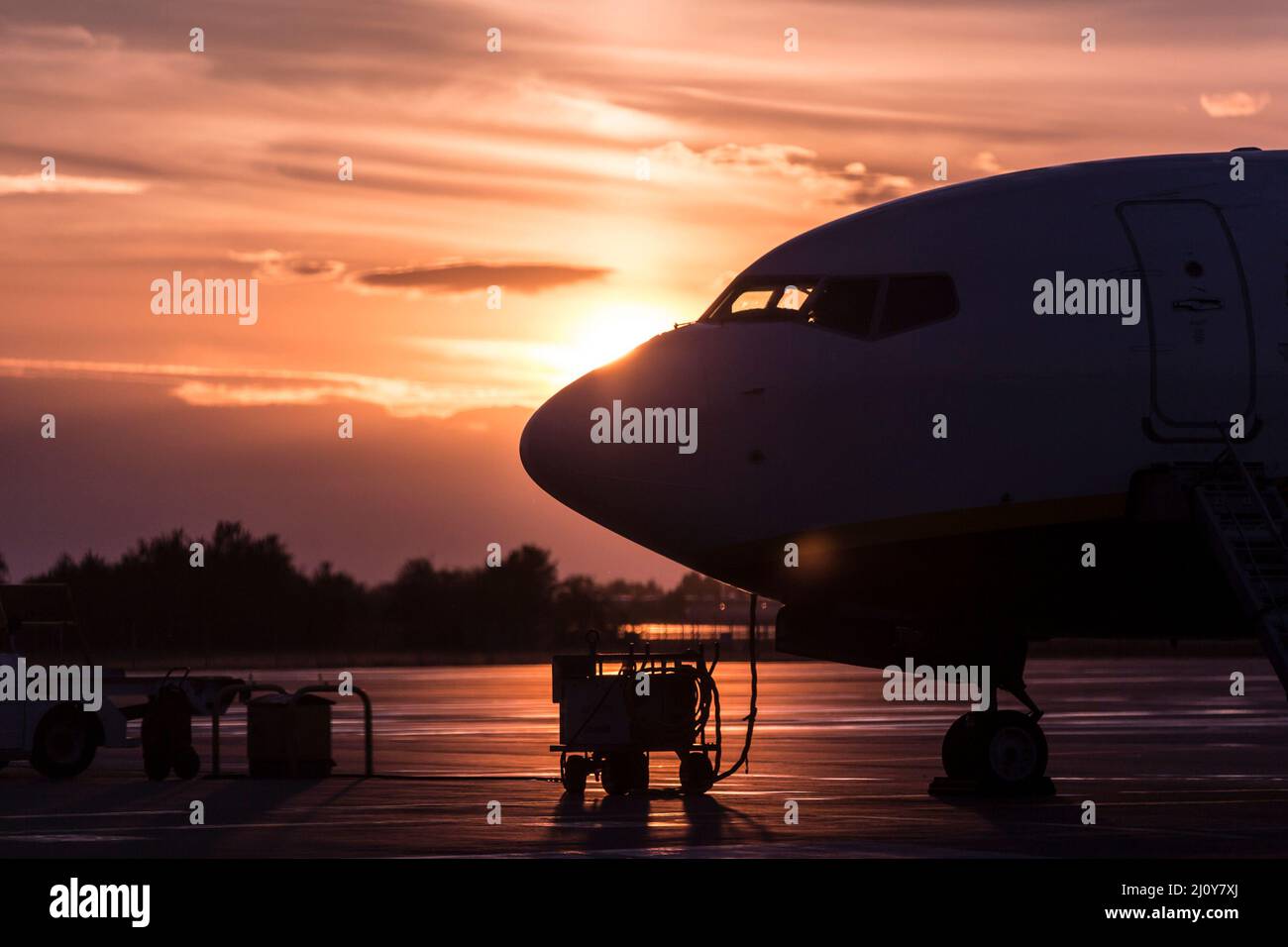 Parked airplane side view backlit, sunset time. Narrow body commercial jet airplane Stock Photo