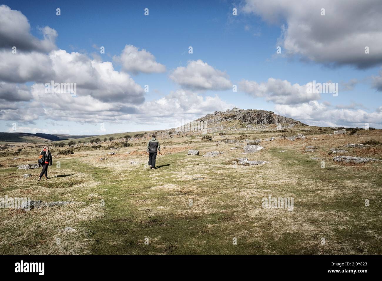 Walkers walking towards Stowes Hill on the rugged Bodmin Moor in Cornwall.The Cheesewring. Stock Photo