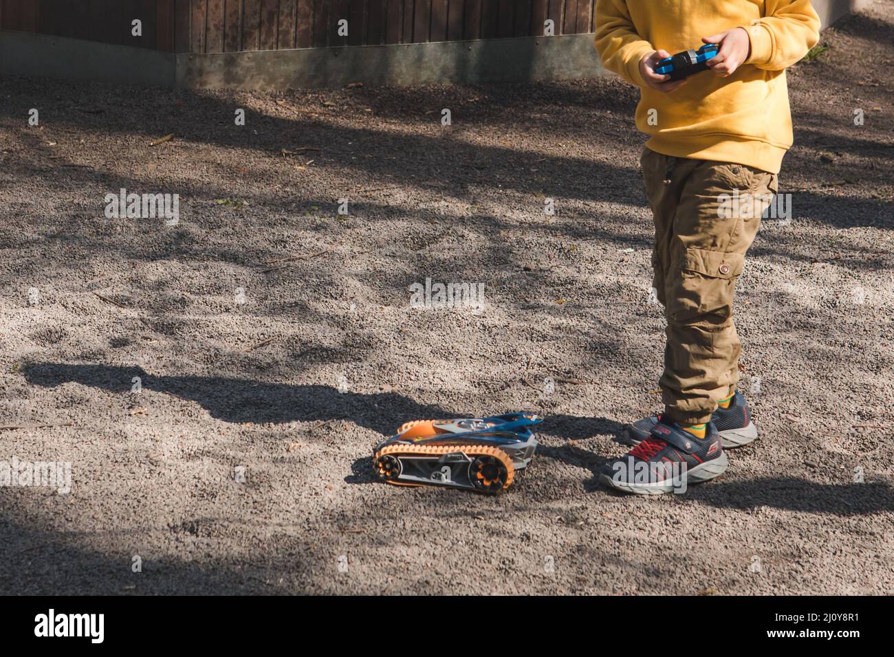 toddler boy playing outside with radio remote control car Stock Photo