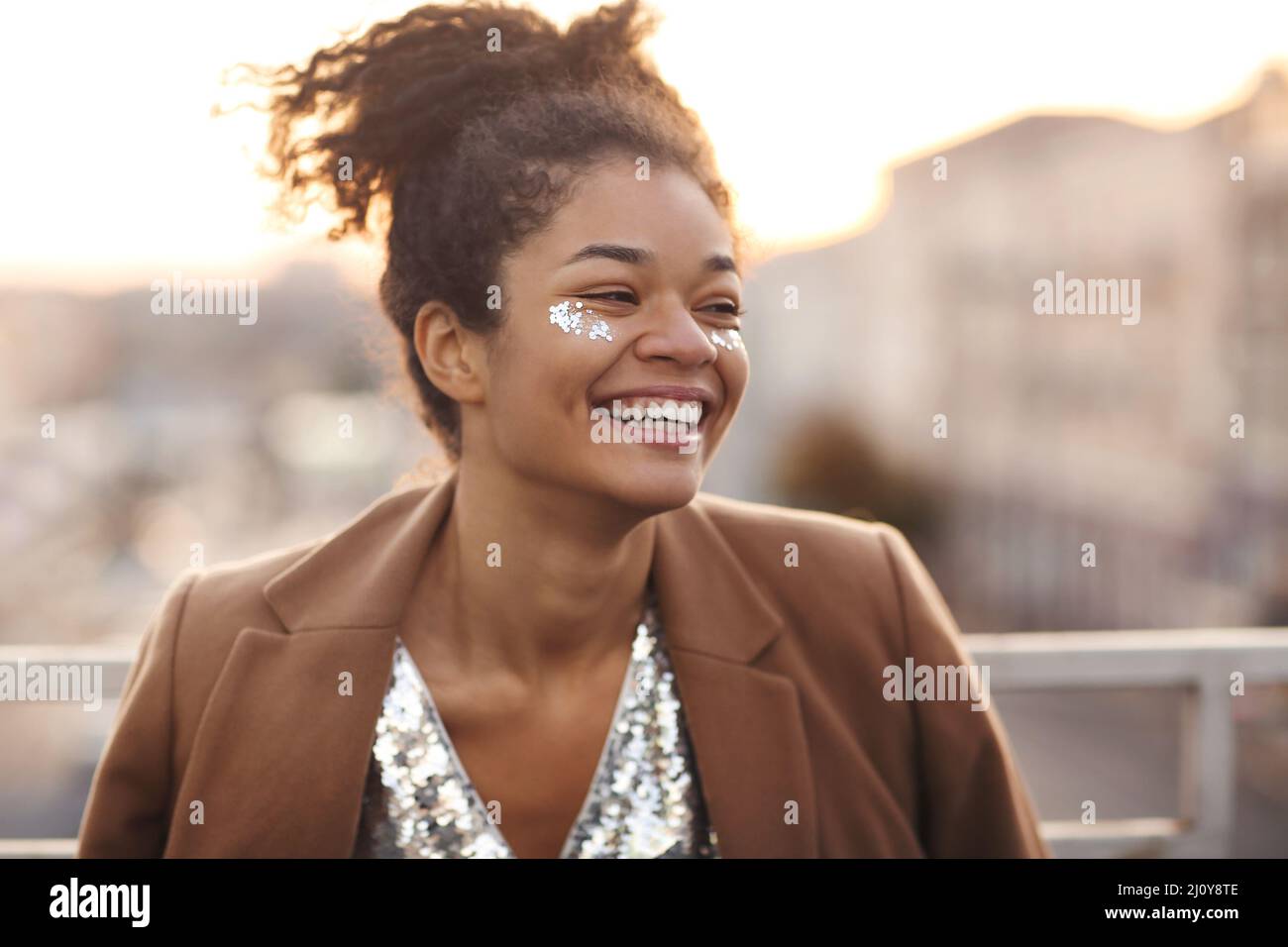 Outdoor portrait of happy glamour african american woman with glitter on face Stock Photo