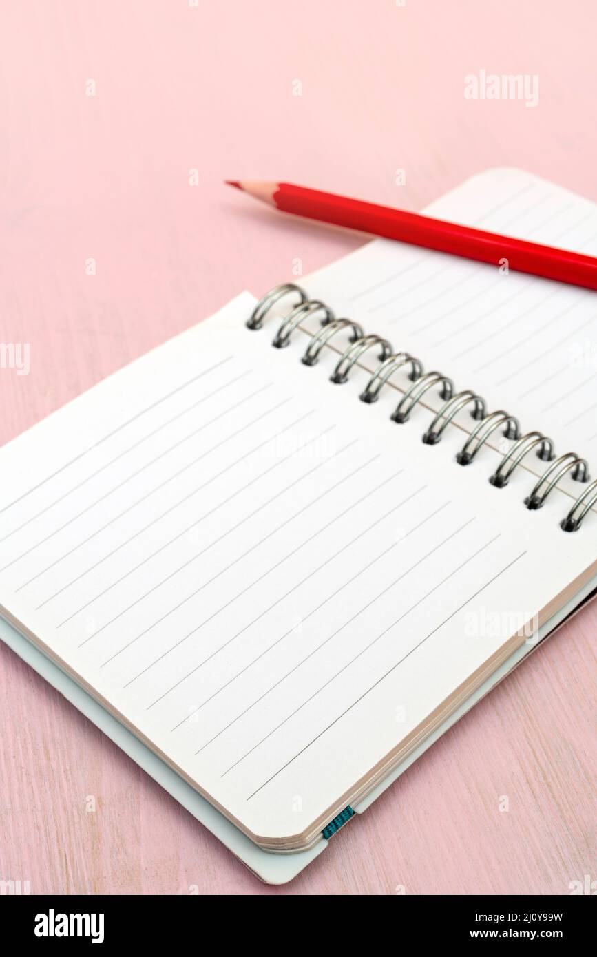 Red pencil and notebook for notes. Stock Photo