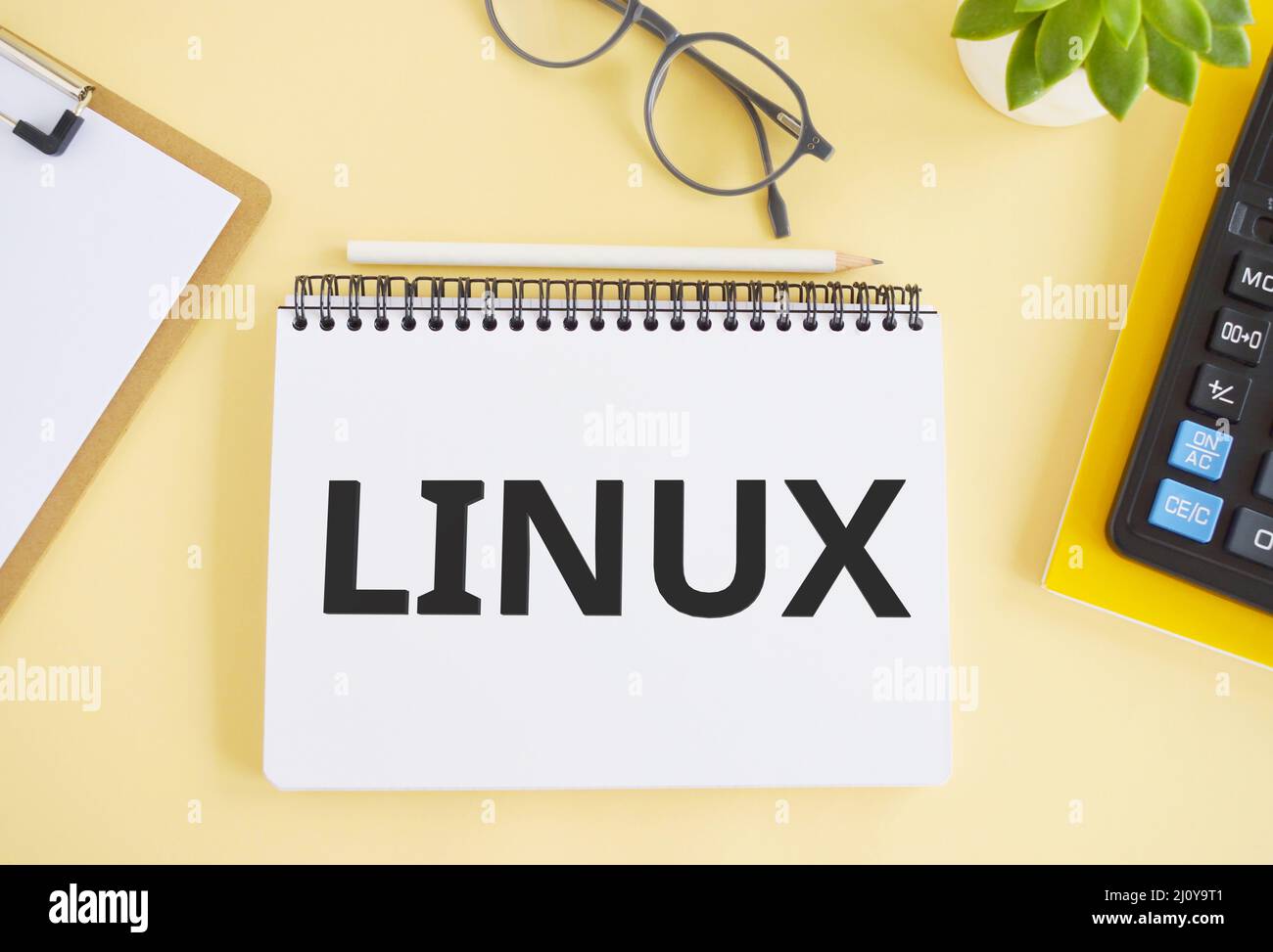 LINUX. Text written in Noebook on light background. Technology concept. Flat lay. Stock Photo