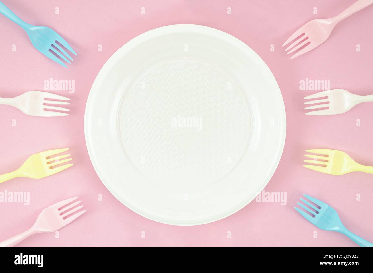 Colorful plastic dishes pink background. High quality photo Stock Photo