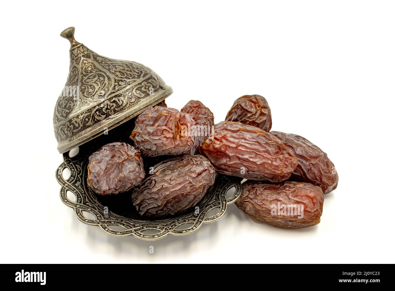 Date fruit isolated on a white background. Date fruits on a rustic serving plate Stock Photo