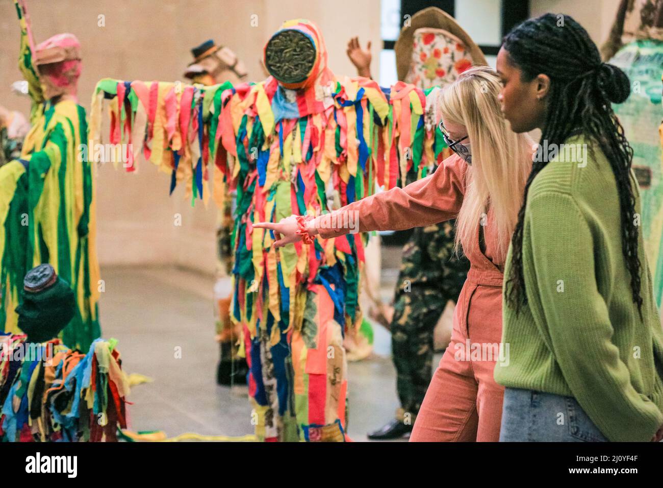 London, UK, 21st March 2022. Tate staffers with 'The Procession', which is one large installation with many different elements. Influence of both Indian and Indo-Caribbean culture, including many carnival elements, can be seen. According to Locke, 'The Procession' is not a historic textbook, but rather an 'extended poem of contrasting references and imagery. The annual Tate Britain Commission has been undertaken by Guyanese-British artist Hew Locke with 'The Procession'. Credit: Imageplotter/Alamy Live News Stock Photo