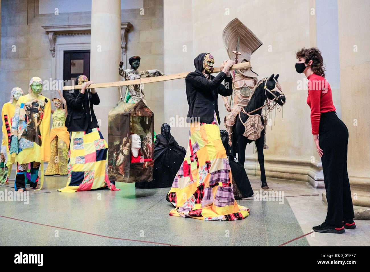 London, UK, 21st March 2022. Tate staffers with 'The Procession', which is one large installation with many different elements. Influence of both Indian and Indo-Caribbean culture, including many carnival elements, can be seen. According to Locke, 'The Procession' is not a historic textbook, but rather an 'extended poem of contrasting references and imagery. The annual Tate Britain Commission has been undertaken by Guyanese-British artist Hew Locke with 'The Procession'. Credit: Imageplotter/Alamy Live News Stock Photo