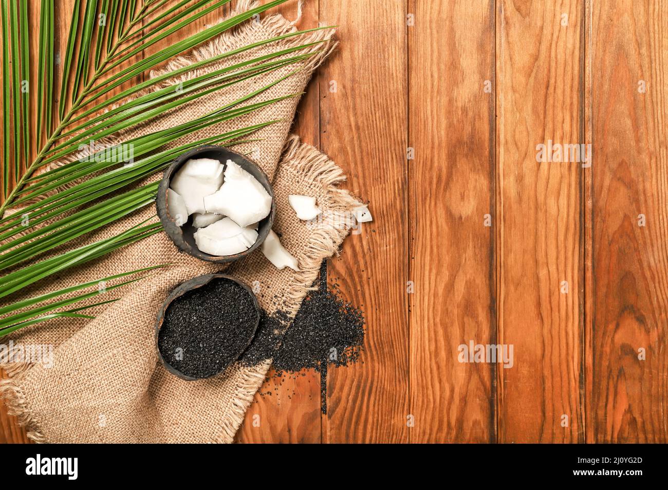 Coconut shells with activated carbon on wooden background Stock Photo