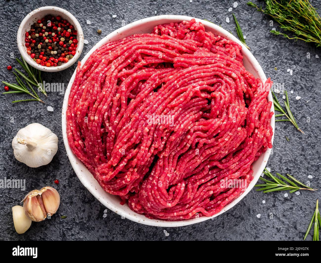 Mince beef, ground meat with ingredients for cooking on dark blue Stock Photo