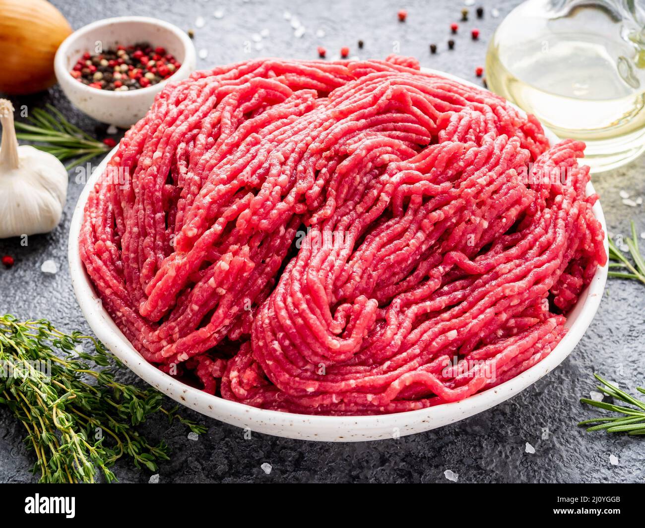 Mince beef, ground meat with ingredients for cooking on dark blue Stock Photo