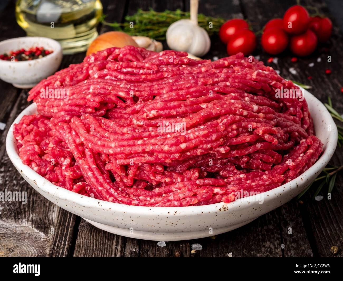 Mince beef, ground meat with ingredients for cooking on dark blue Stock Photo