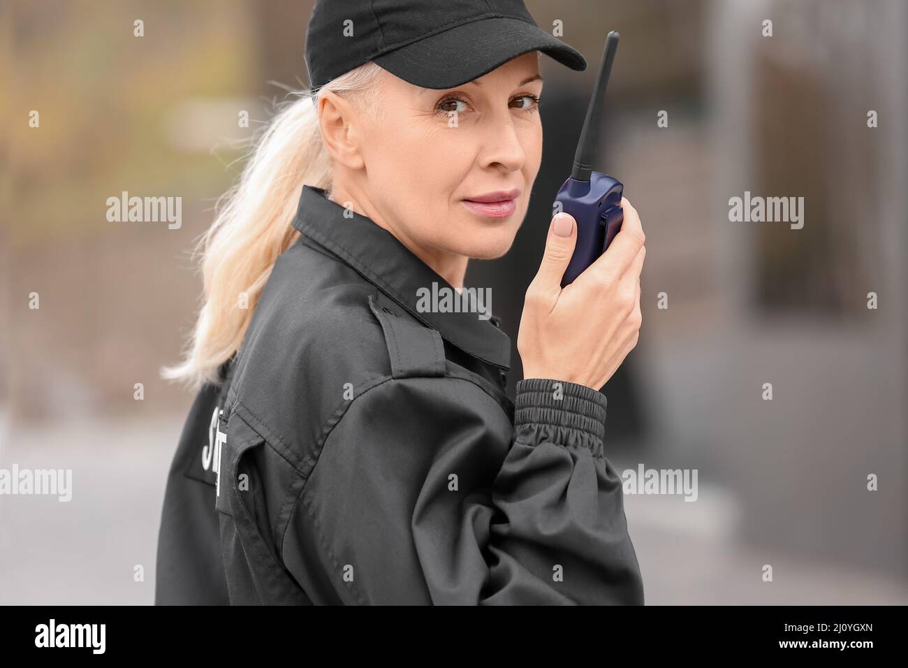 Female security guard with radio transmitter outdoors Stock Photo Alamy