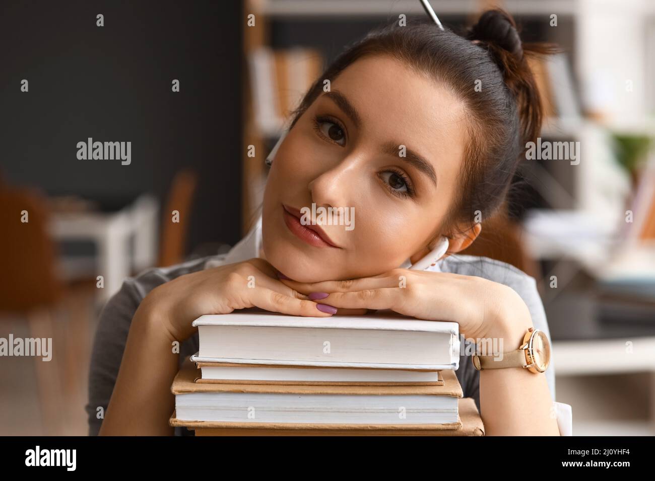 Beautiful female student with stack of books in library Stock Photo - Alamy