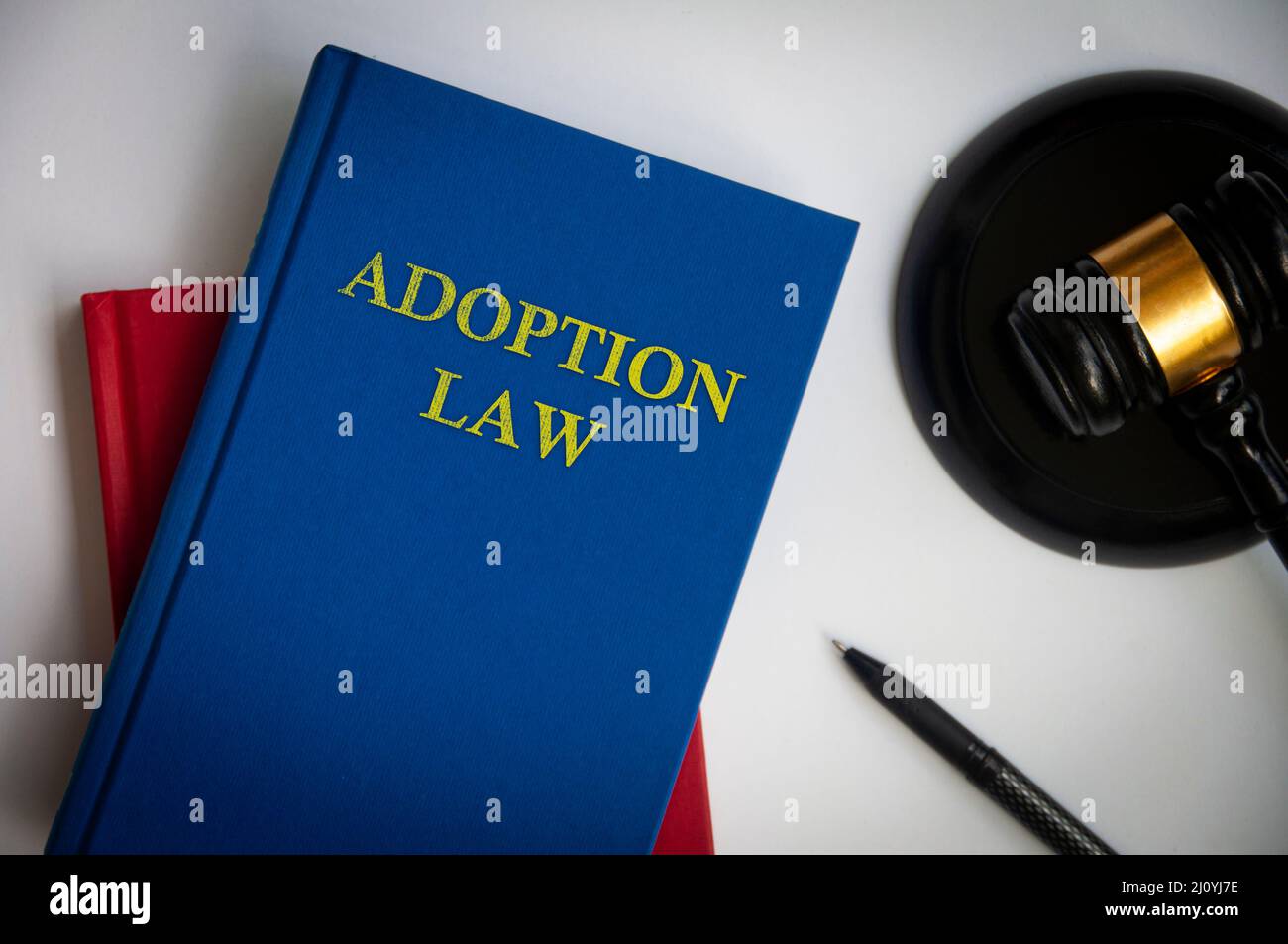 Top view of Adoption law book with gavel and pen on white background. Law concept. Stock Photo