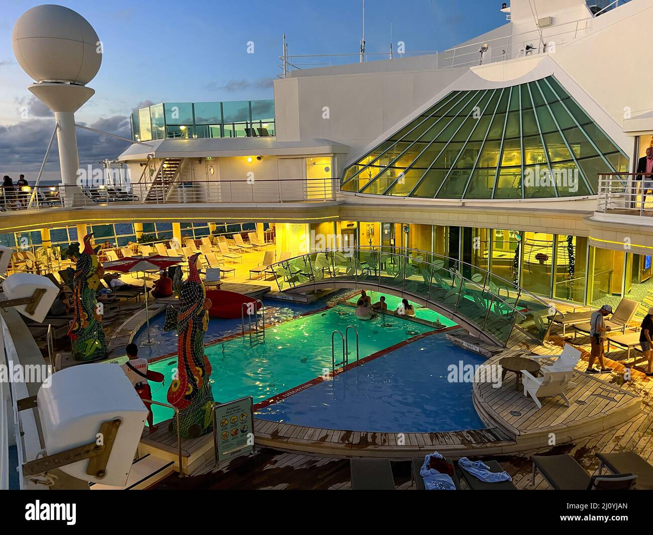 Orlando, FL USA - December 6, 2021:  The  Solarium swimming pool area st night on the Royal Caribbean Cruise Ship Independence of the Seas in Port Can Stock Photo