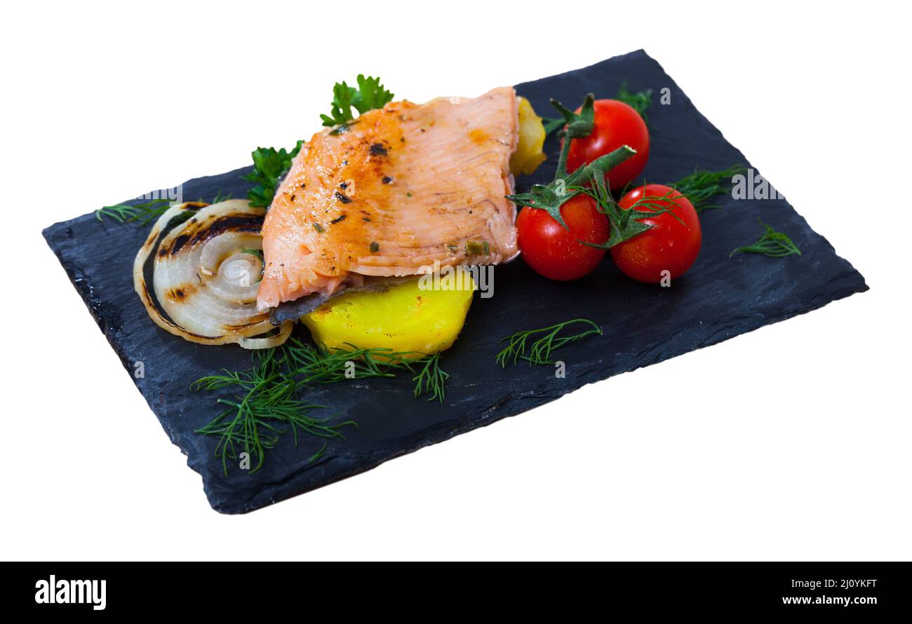 Deliciously fried trout fillets with potatoes, cherry tomatoes and greens Stock Photo