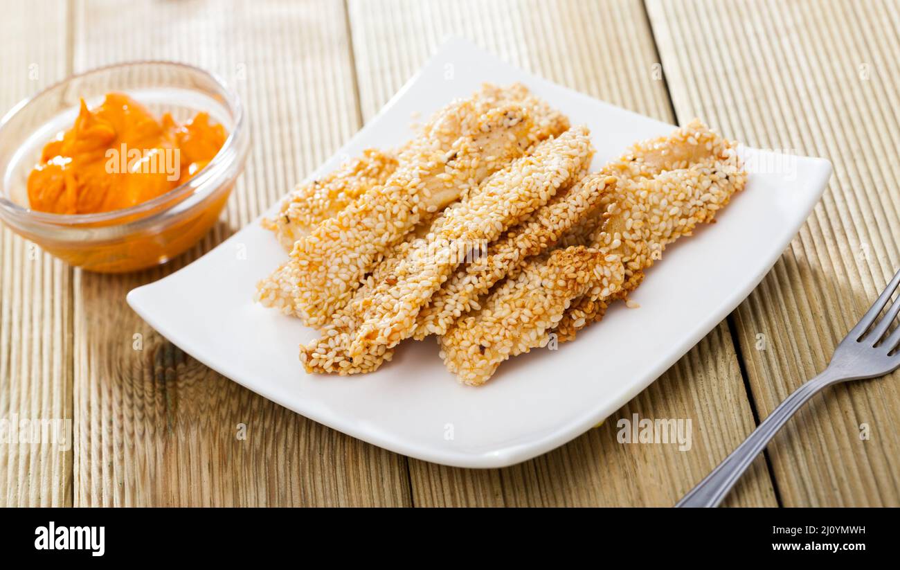 Chicken strips in sesame with sauce Stock Photo Alamy