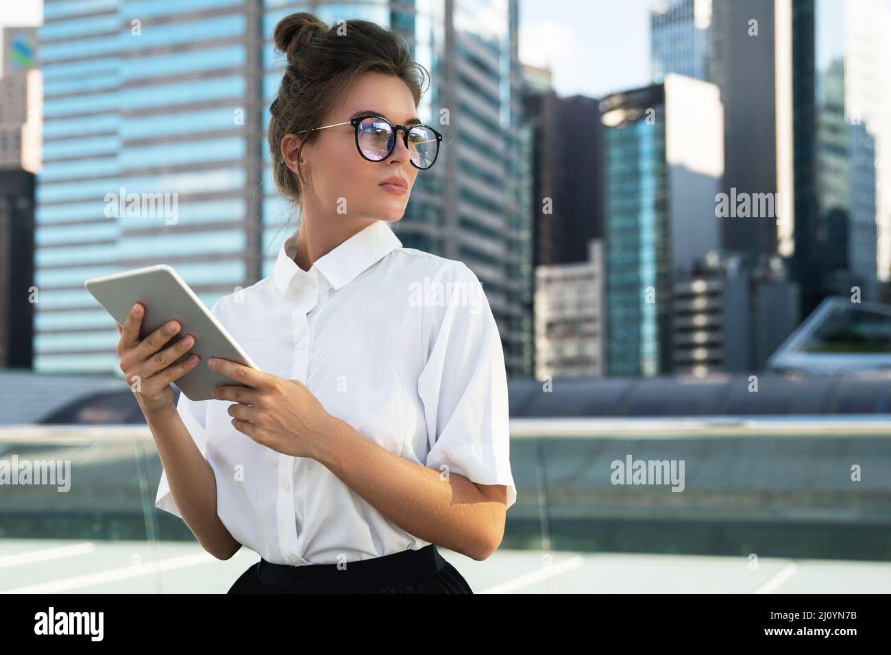 Woman wearing smart casual clothing is using tablet pc Stock Photo