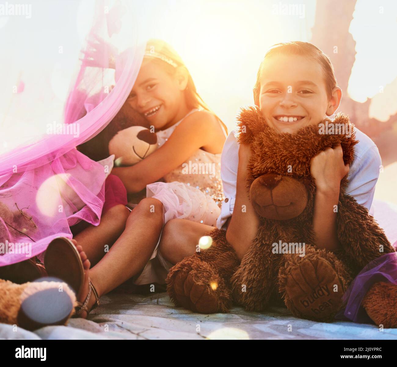 We both have our favourite teddybear. Shot of an adorable little brother and sister playing outdoors. Stock Photo