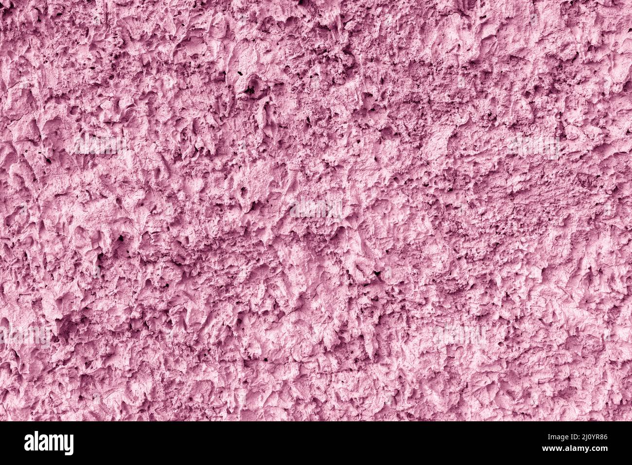 Pink texture of uneven plaster on the wall of the house. Stock Photo