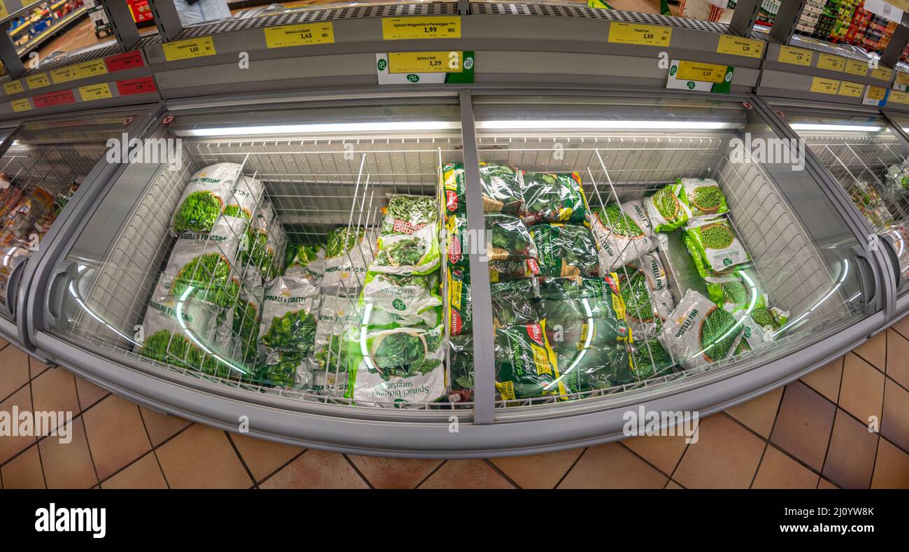 Fossano, Italy - March 12, 2022: Refrigerated counter with packs of frozen vegetables for sale in INS supermarket discount store, PAM group. Fish eye Stock Photo