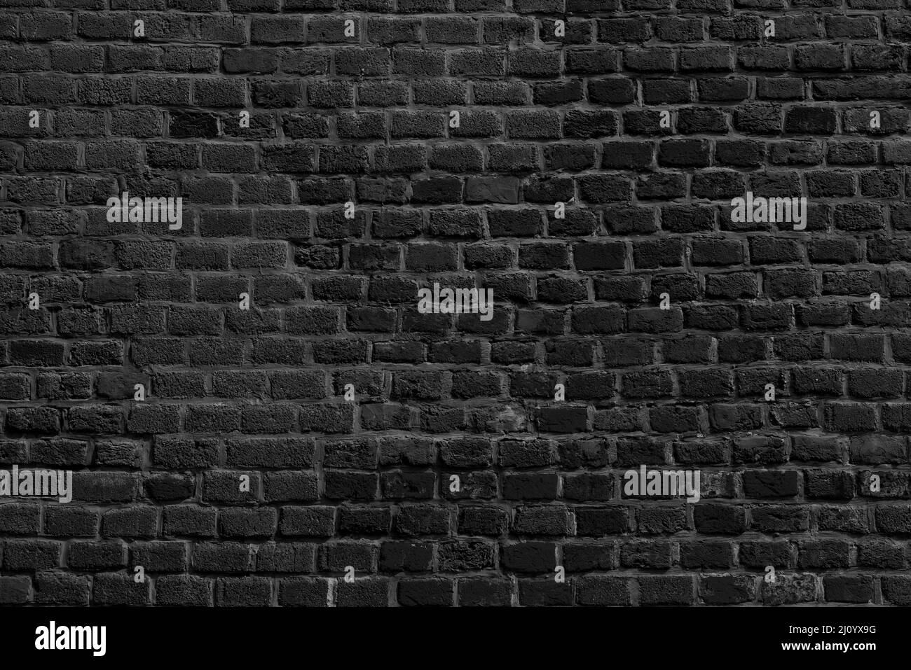 The background of the old black brick wall for design interior Stock