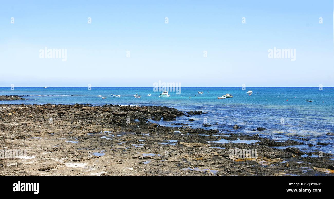 Boats stranded on the beach at Costa Teguise in Lanzarote, Canary Islands, Spain, Europe Stock Photo