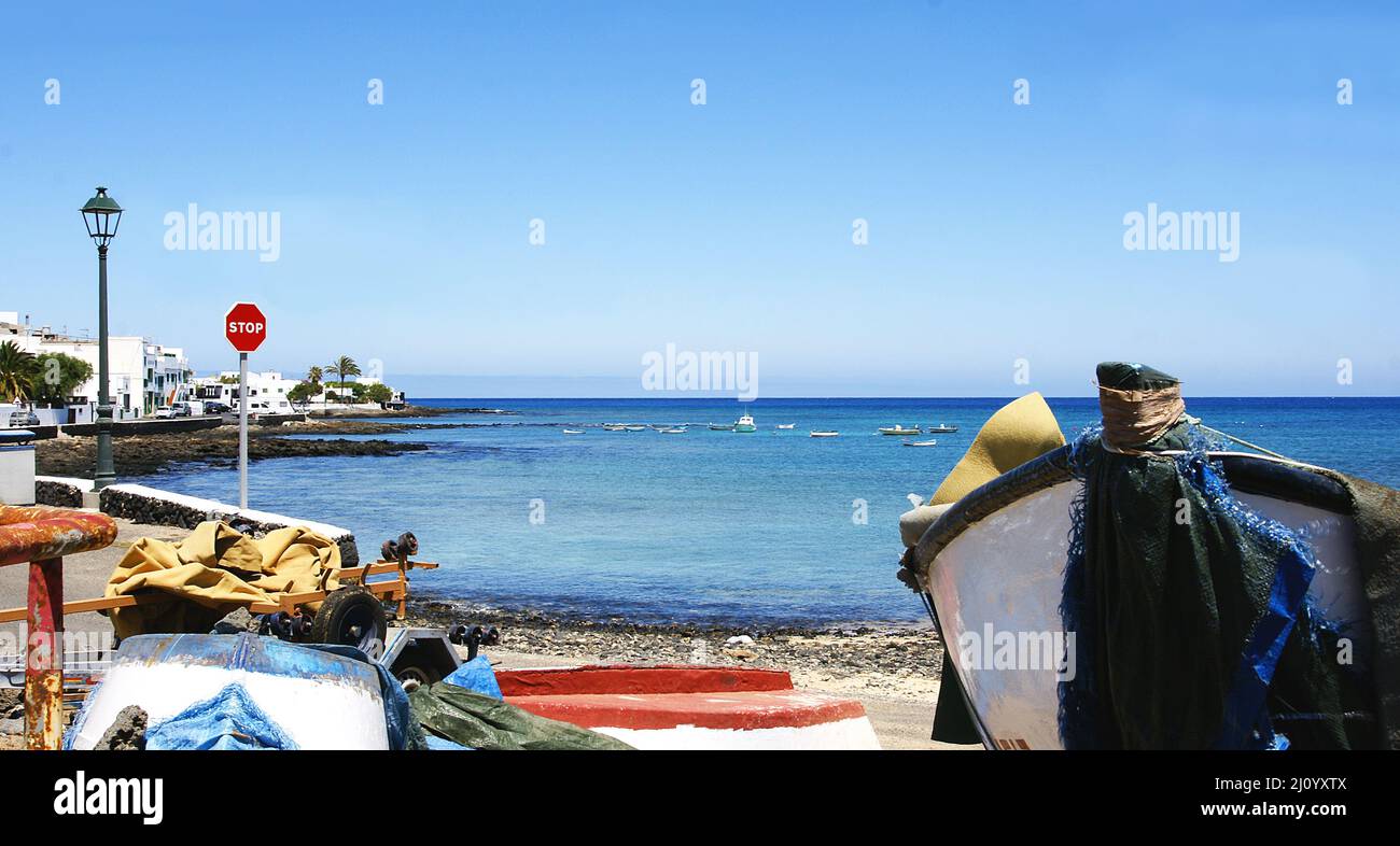 Boats stranded on the beach at Costa Teguise in Lanzarote, Canary Islands, Spain, Europe Stock Photo