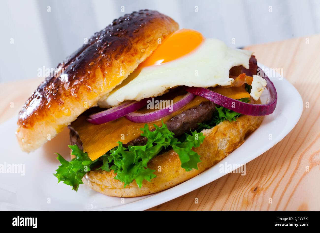 Delicious hamburger with beef cutlet, fried egg, lettuce and cheese