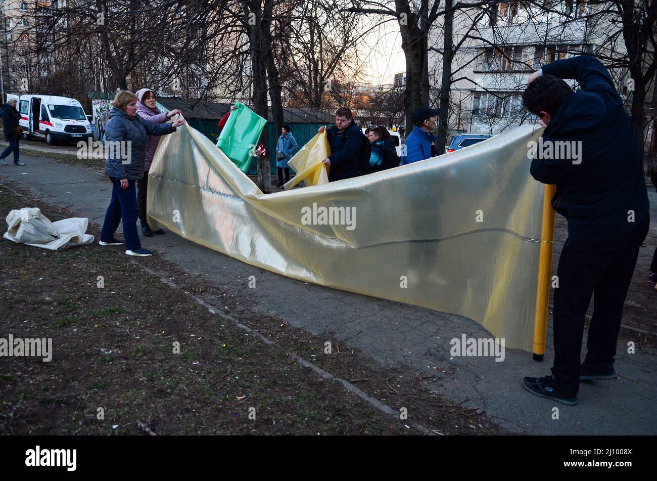 KYIV, UKRAINE - MARCH 20, 2022 - People get the film to seal their smashed windows at a residential building damaged as a result of shelling by Russia Stock Photo