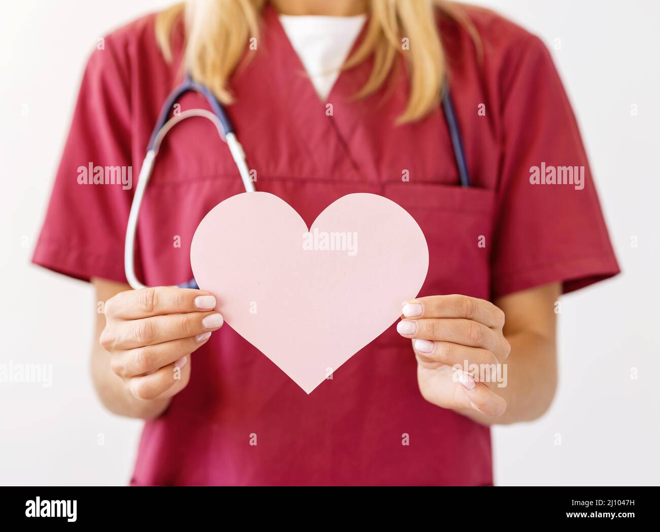 Front view female doctor with stethoscope holding paper heart Stock Photo