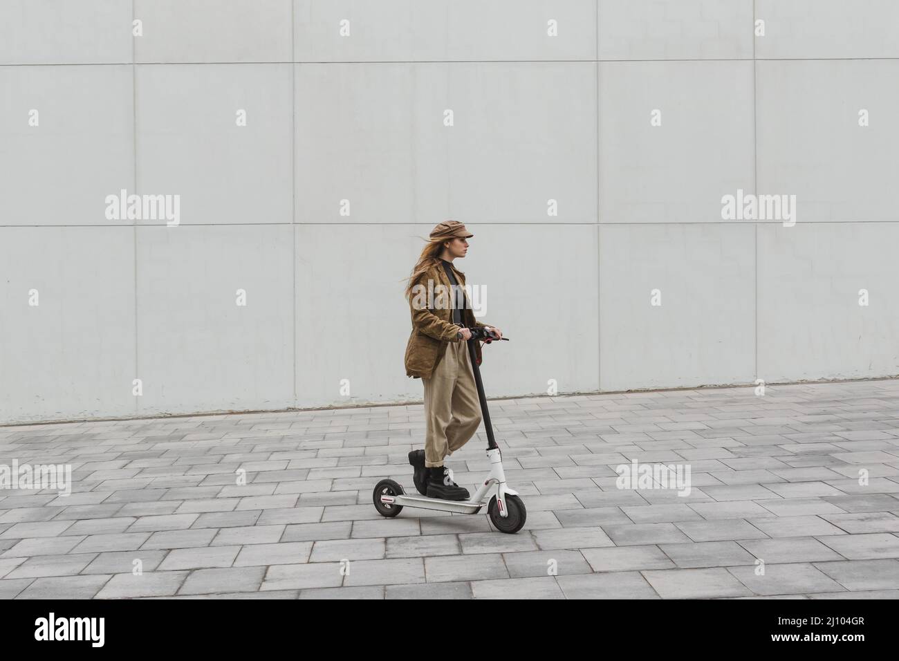 Young woman riding electric scooter Stock Photo