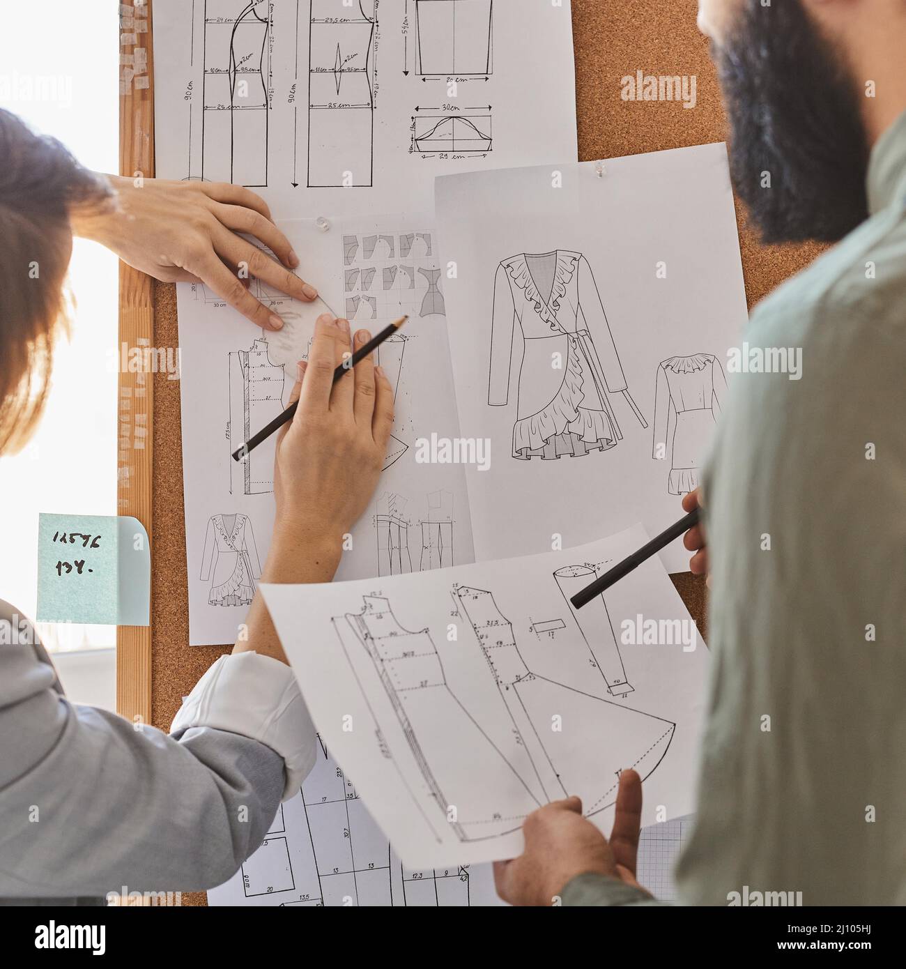 Fashion designers consulting plans new clothing line idea board Stock Photo