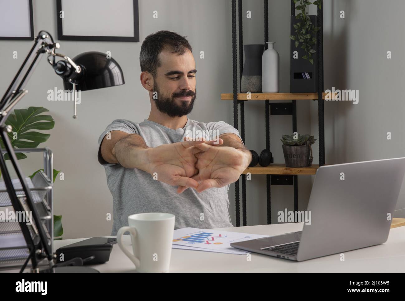 Man stretching his arms while working from home Stock Photo Alamy