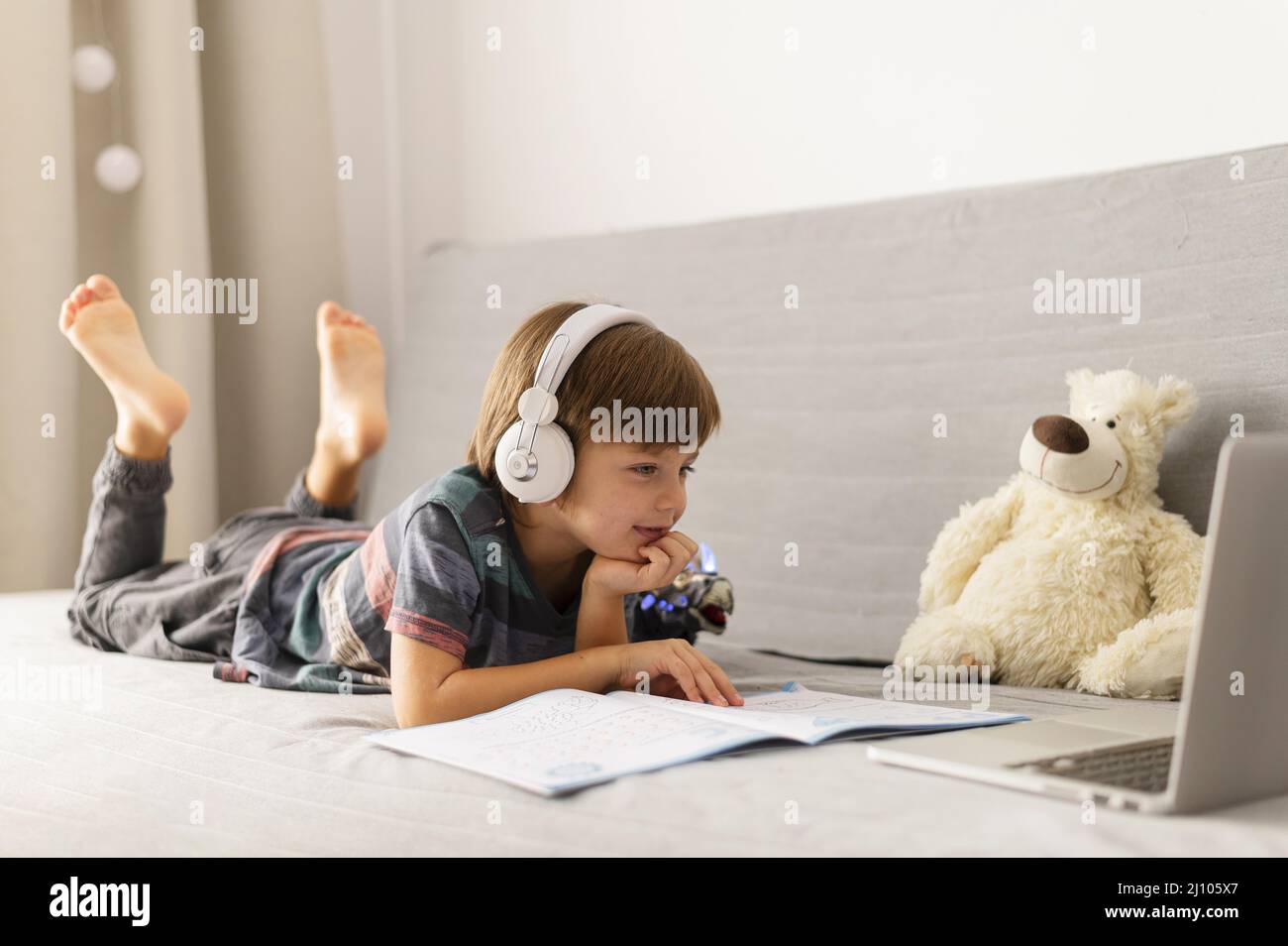 Long shot child attending virtual school courses Stock Photo