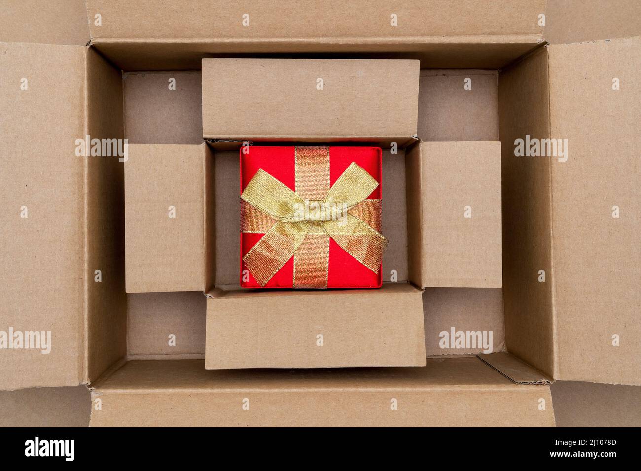 Opened large cadboard box with red gift box inside Stock Photo