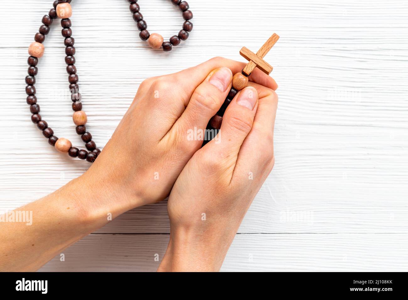 Female hands holding christian rosary beads with cross Stock Photo - Alamy