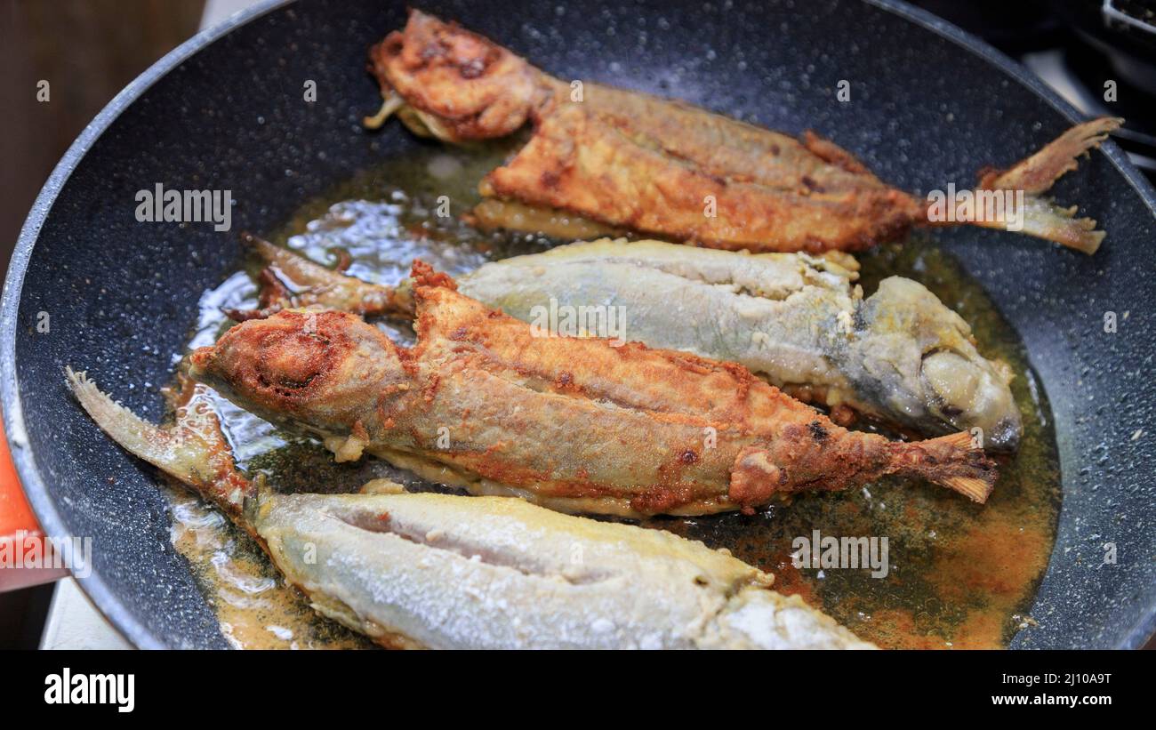 frying fish in coconut oil in a non stick frying pan Stock Photo