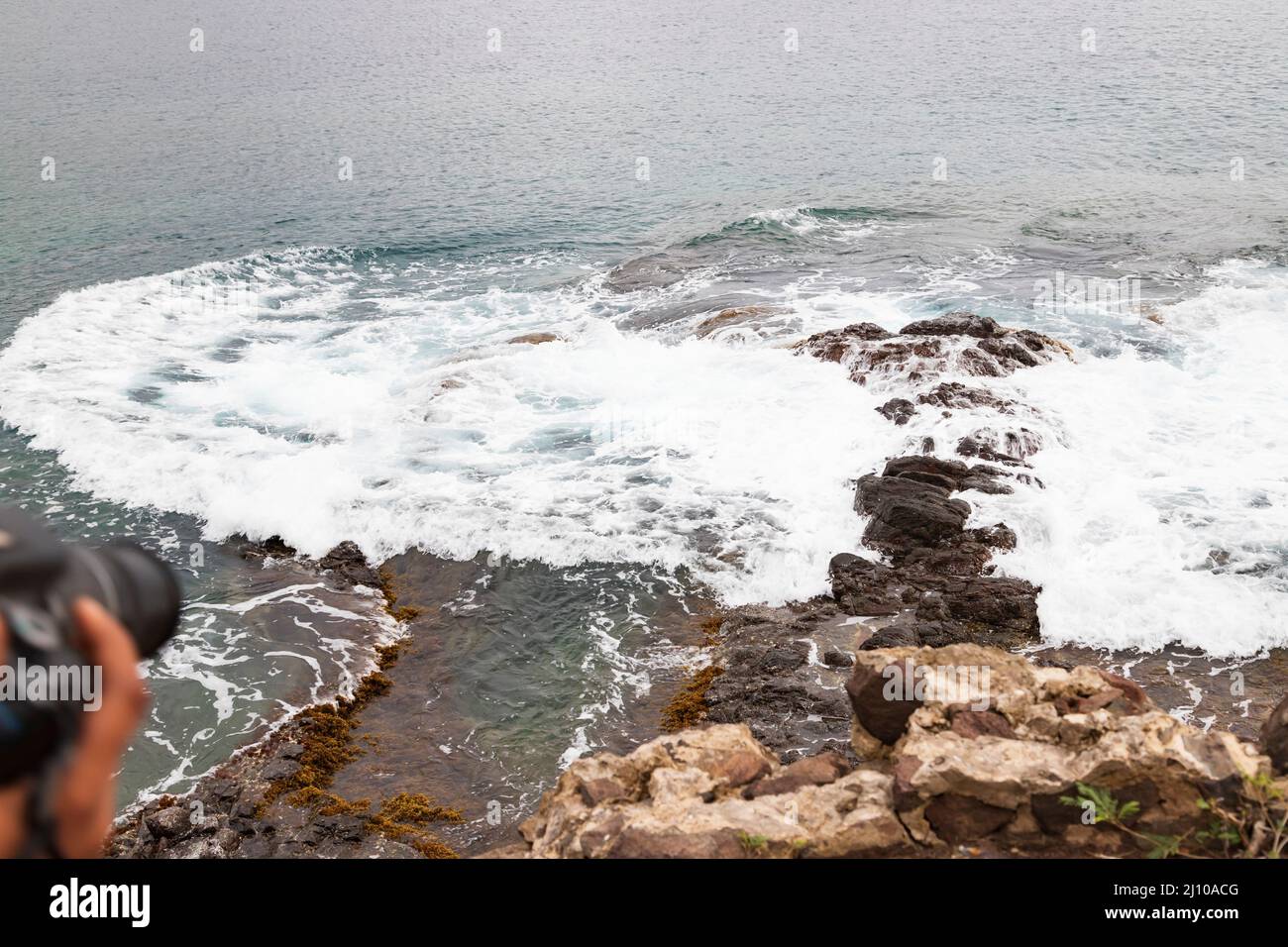 Sea level receding, exposing rocks and coral Stock Photo
