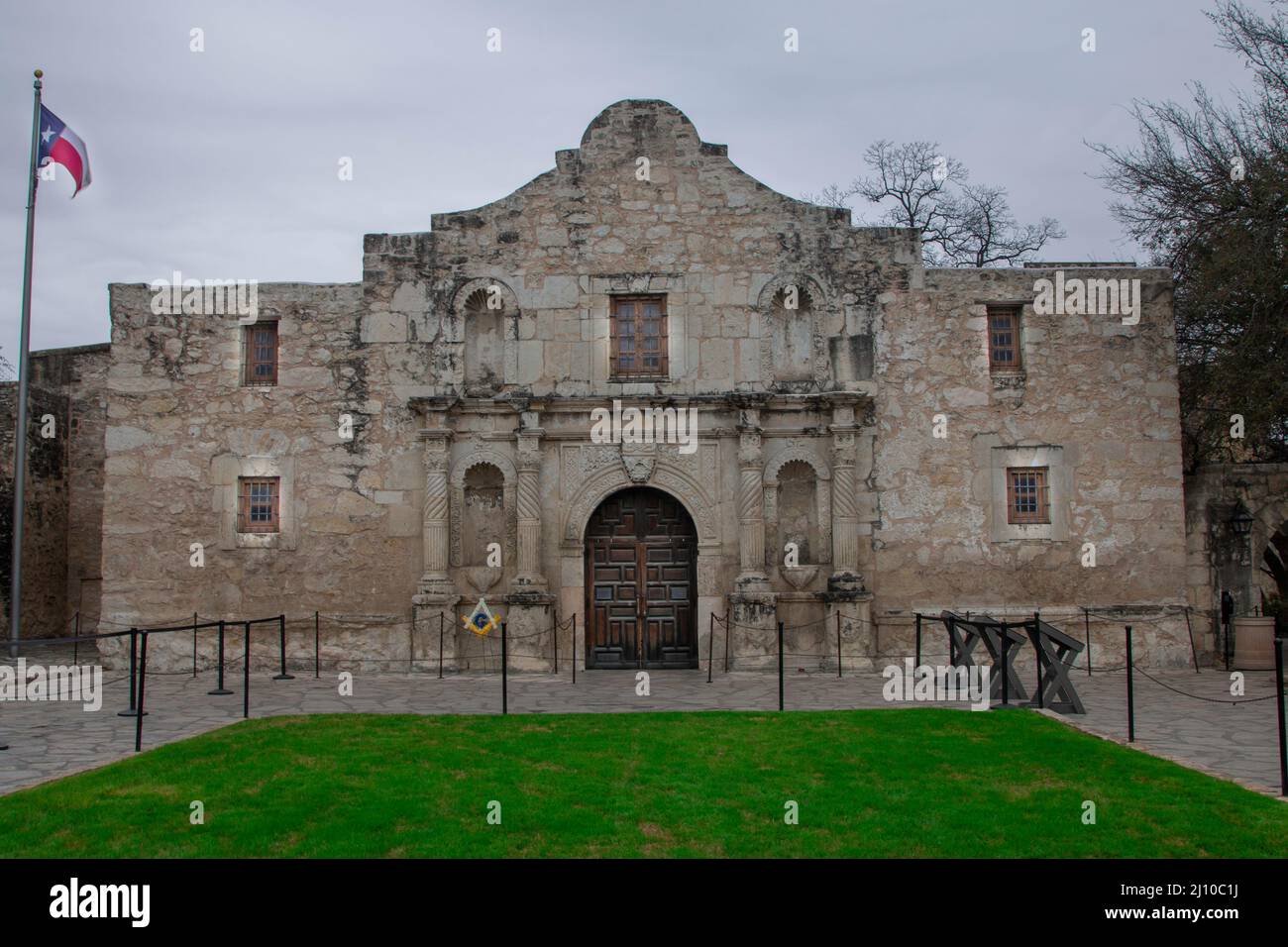 The flag of Texas flies over the entrance to the mission of the Alamo Stock Photo