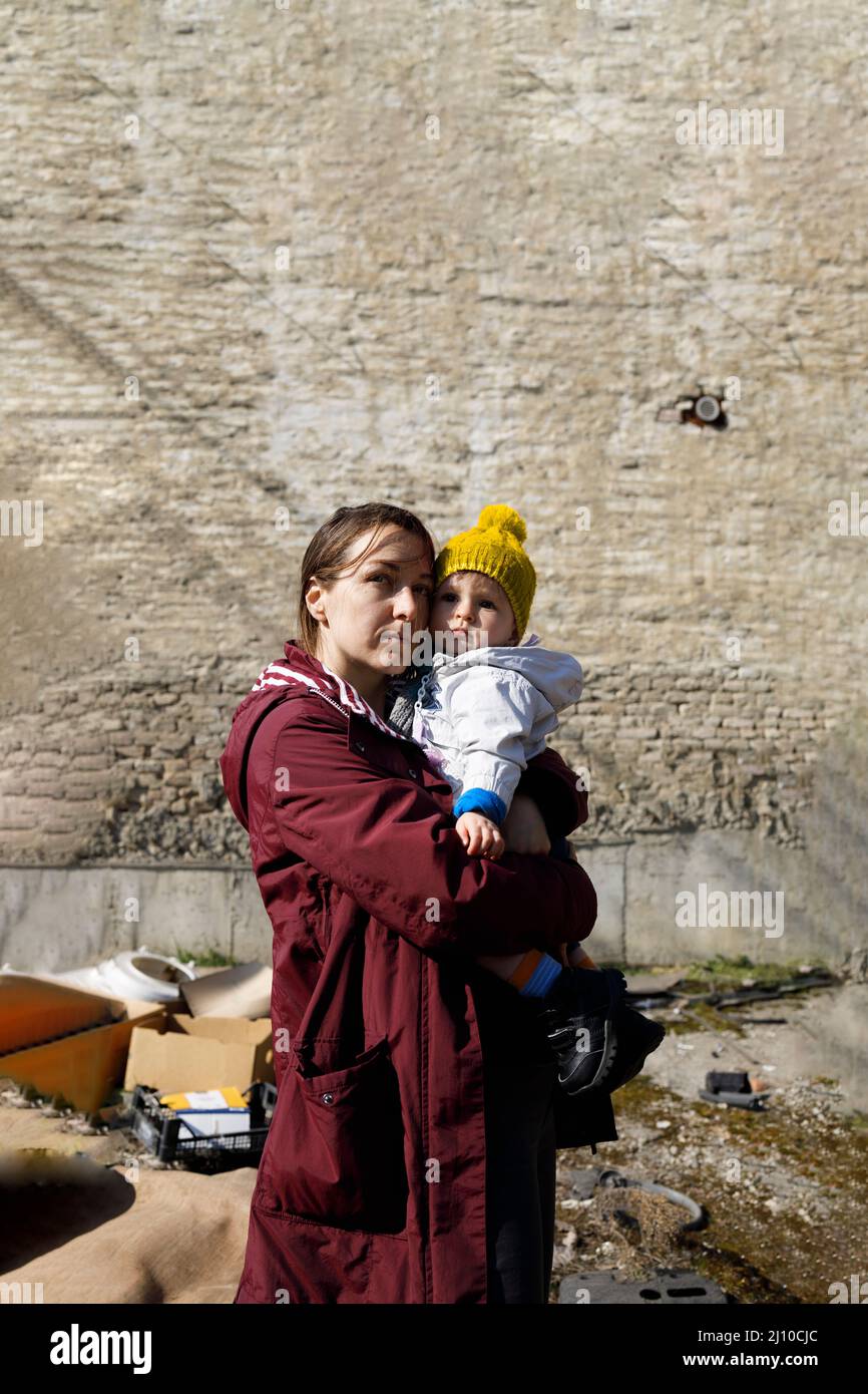 Portrait of a mother and her child by a devastated wall Stock Photo