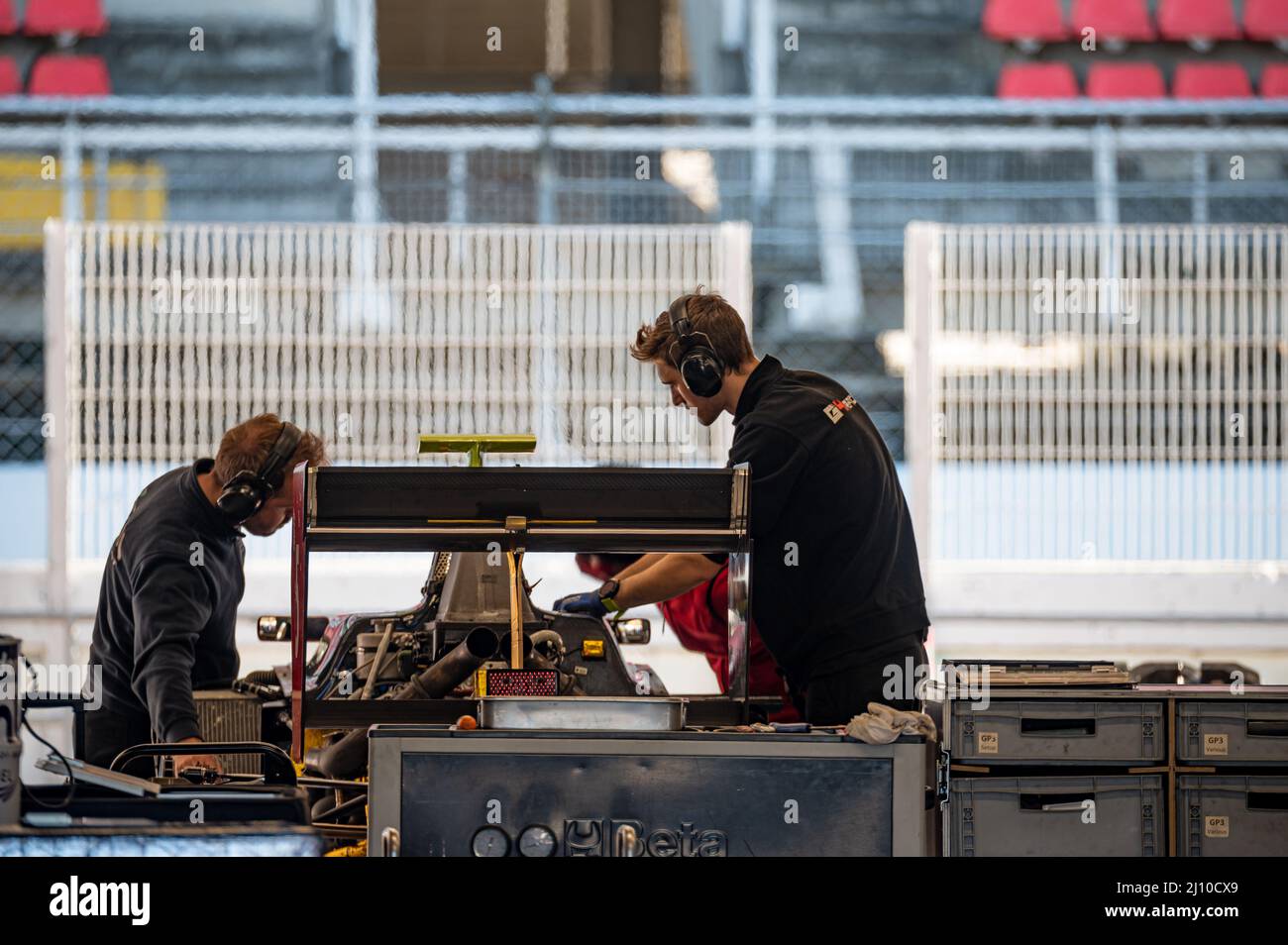 Closeup of Mechanics and track engineers tuning the race car in the