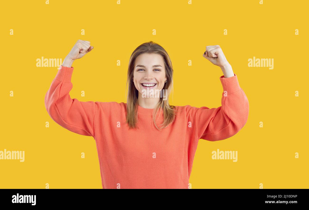 Happy confident lady smiling and flexing her arms illustrating Girl Power concept Stock Photo