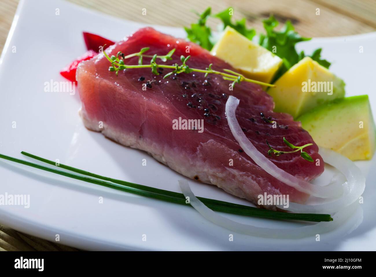 Seared tuna steaks with avocado, greens Stock Photo Alamy