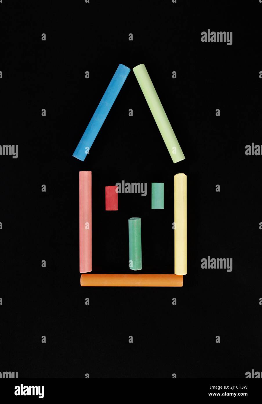 Colorful house shape with multicolored pieces of chalk on black background Stock Photo